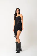 Borcegos de caña alta (30 cm) color negro, confeccionados en ecocuero, con suela gruesa y bajo relieve. Presentan una correa con hebilla metálica plateada alrededor del tobillo y una correa ajustable con hebilla en la caña superior.