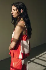 Top blanco con estampado de círculos rojos, escote redondo, breteles finos y corte evasé.