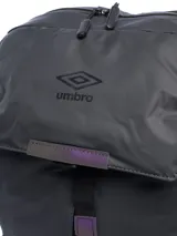 Mochila negra de estilo moderno con solapa superior que se cierra con hebilla ajustable. Presenta el logo de Umbro en relieve en la solapa. Cuenta con un bolsillo lateral para botella o termo.
