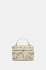 Bolso rígido color blanco con apliques de lentejuelas y cuentas doradas y plateadas. Tiene asa de mano y asa de cadena extraíble para usar como bandolera. Cierre con cremallera.