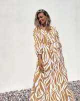 Vestido largo tipo túnica con estampado de cebra en tonos beige y crudo, con cuello en V y mangas 3/4.