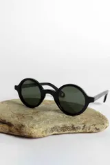 Lentes de sol con montura redonda negra y cristales verdes.