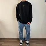 Pantalón jean cargo negro con corte holgado y múltiples bolsillos.