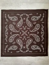 Pañuelo cuadrado color marrón con estampado de arabescos en blanco y borde celeste.