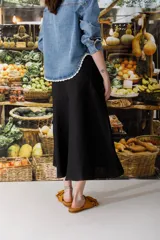 Falda midi negra de jean con costuras a contratono color ocre.