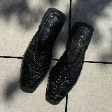 Zueco de cuero color marrón con diseño fruncido en la parte delantera y taco bajo.