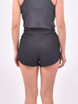 Short blanco con rayas horizontales rojas, cintura elastizada con cordón ajustable y bolsillos laterales.