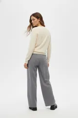 Cardigan negro de acrílico, ajustado al cuerpo, con cuello a la base, manga larga y cierre frontal con botones.