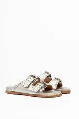 Sandalias marrones de cuero vacuno con doble tira y hebillas metálicas ajustables.