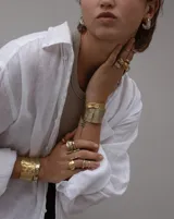 Pulsera tipo esclava abierta, con acabado rústico y textura irregular, en tono plateado. Se vende por unidad.