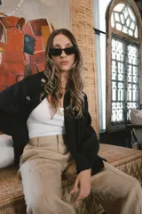 Camisa blanca de lino con bordados dorados de árboles, corte recto, cuello camisero y mangas largas con puños abotonados.