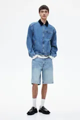 Bermuda de denim celeste, de corte recto y largo hasta la rodilla.