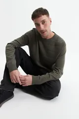 Buzo de punto color beige, con cuello redondo y mangas largas. Tejido con textura piquet y puños acanalados. Corte regular.