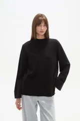 Sweater de viscosa color beige, con cuello polera, corte holgado y pespuntes decorativos en el frente.