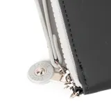 Billetera grande color negro con cierre perimetral y herrajes plateados. Presenta un parche circular frontal con el texto "EXTRA XL LARGE".