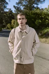 Camisa de denim color beige claro, corte amplio, cuello clásico, cierre frontal con botones y mangas largas. Confeccionada en tejido denim de sarga con acabado acid wash.