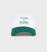Gorro de béisbol blanco con visera verde y logo bordado en verde con la frase "Health is Wealth!".