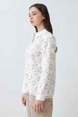 Camisa fucsia de broderie con cuello clásico, cierre frontal con botones y mangas largas.