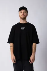 Remera negra de algodón con corte oversize y estampa frontal con texto en blanco.