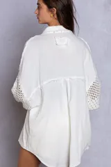 Camisa blanca oversize de doble gasa con manga de jersey moderna en contraste. Presenta bolsillos en el pecho y detalles de borde sin rematar. Corte oversize.