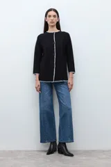 Saco de punto color ciruela oscuro, de manga larga y cuello redondo, con cierre frontal de botones y ribetes en contraste blanco con puntada decorativa.