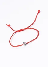 Pulsera roja de hilo trenzado con nudo corredizo ajustable y dije de punto de luz con engarce plateado.