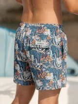 Short de baño azul con estampado floral en tonos blanco, naranja y verde. Tiene elástico en la cintura, cordón ajustable, bolsillos laterales y un bolsillo trasero con botón. Marca Von Braun.