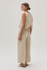 Pantalón de vestir color beige, de corte ancho y tiro alto, con cintura elástica ajustable con cordón.