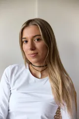 Gargantilla de cuero negro con dije de piedra blanca en forma de lágrima con engarce dorado.