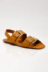 Sandalias negras de cuero con dos tiras anchas sobre el empeine, hebillas doradas y tira trasera.