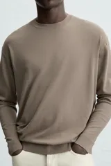 Jersey color topo de corte amplio, tejido en hilatura con mezcla de viscosa. Tiene cuello redondo, manga larga y terminaciones en rib.
