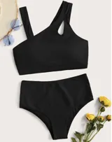 Conjunto de bikini negro con top asimétrico de un solo hombro con abertura circular y bombacha de tiro alto.