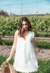 Vestido corto blanco con bordado calado, escote en V y corte imperio.