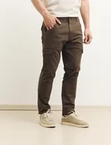 Pantalón de gabardina color marrón, corte slim fit, con bolsillos laterales tipo cargo.
