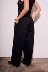 Pantalón negro de corte amplio, con cintura elástica y textura arrugada.