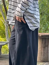 Remerón negro de manga larga, corte oversize con espalda más larga, tajos laterales y bajo redondeado.