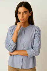 Camisa celeste de viscosa, corte holgado, con cuello mao y cierre frontal con botones.