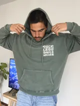 Canguro verde oliva con capucha y estampado en la espalda con la frase "Talk Less Smile More".