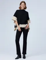Poncho tejido de punto, color negro con bloques de color beige en los bordes y puños. Presenta un cuello vuelto asimétrico tipo capucha.
