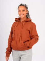 Campera deportiva unisex color ladrillo con capucha, cierre frontal y bolsillos tipo canguro. Confeccionada en algodón con felpa.