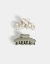 Set de dos broches para el pelo: uno de acrílico con diseño ondulado a rayas color crema y blanco, y otro de plástico color verde oliva.