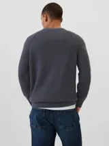 Buzo de punto suave color marrón con cuello redondo y mangas raglán largas.