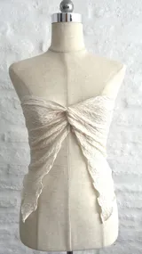 Top color beige, sin mangas y con nudo central.