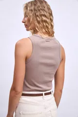 Remera sin mangas color topo, de corte ajustado al cuerpo y cuello redondo.