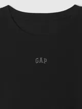 Remera de mujer color crema, de corte ajustado, con cuello redondo y logo de la marca bordado en el pecho.