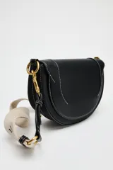 Bolso de hombro ovalado negro con asa de doble tira redonda con detalles metalizados dorados. Cierre imantado y asa de bandolera extraíble con tejido a contraste. Bolso interior con cierre mediante cremallera metálica.