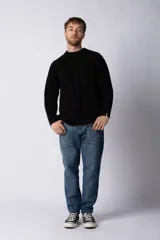 Sweater marrón de punto con cuello redondo y mangas largas raglán. Tejido grueso con textura acanalada. Corte holgado.