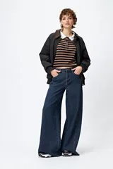 Pantalón jean de calce ultra wide con pierna extra ancha y ruedo desflecado, de tiro medio y construcción clásica en denim.