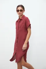 Vestido camisero midi color bordó, de lino, con cuello clásico, mangas cortas, abotonadura frontal y tajo lateral.