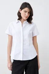 Camisa blanca de corte clásico, con cuello y mangas cortas.